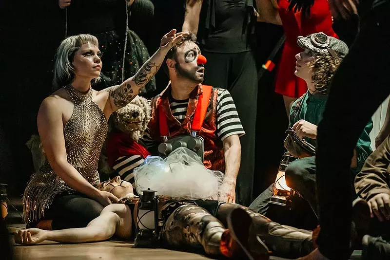 Image: Clowns sit on the ground together.